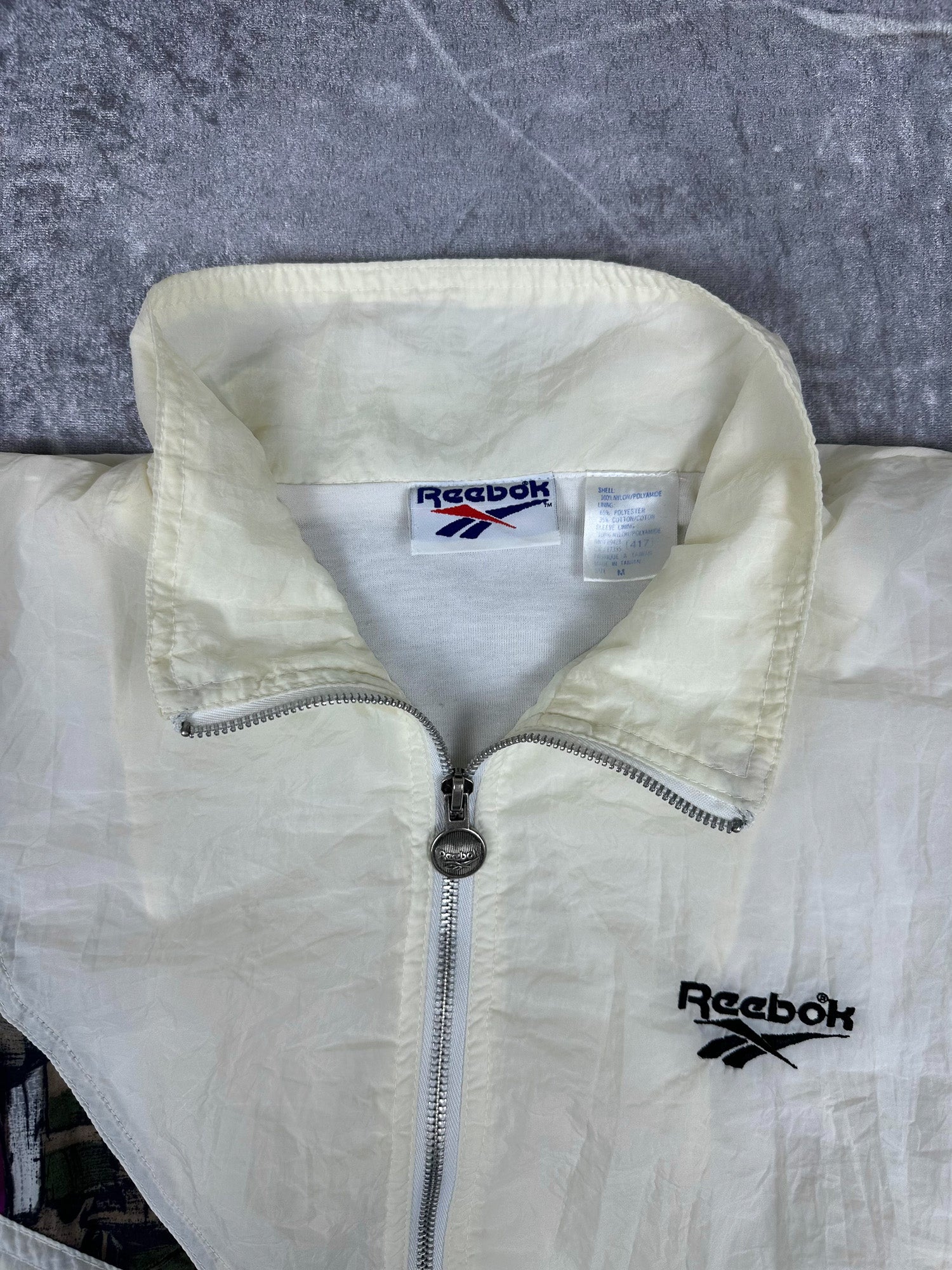 Vintage 90s Reebok Embroidered Logo Abstract Wrap Around Print Windbreaker Jacket (M)